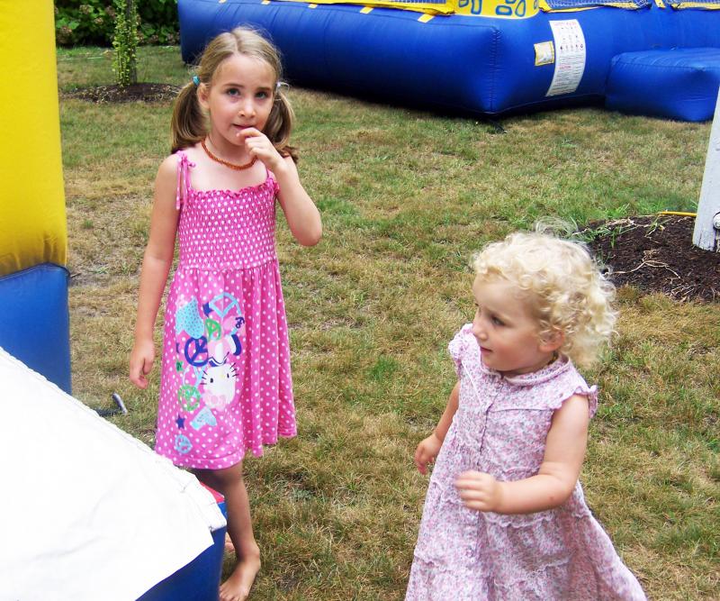 Sisters Mila (left) and Aja Boucher of Mattapoisett head back into one of the bounce houses after heading down a slide. BY MATTHEW BERNAT